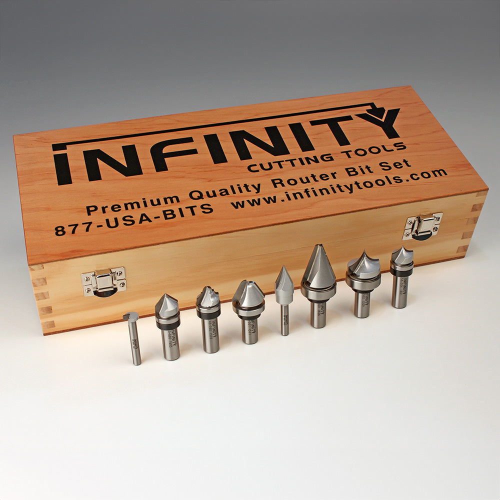Woodworking router bit set with metal bits and wooden storage box on white background