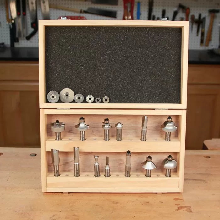 Wood router bit set in wooden case with multiple bits and bearings on a workbench