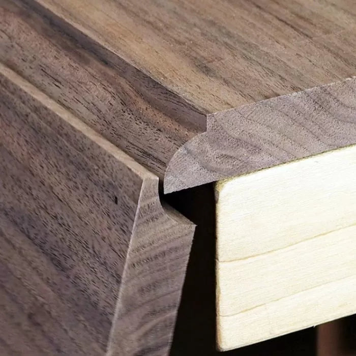 Close-up of walnut wood edge with decorative woodworking joint and smooth finish