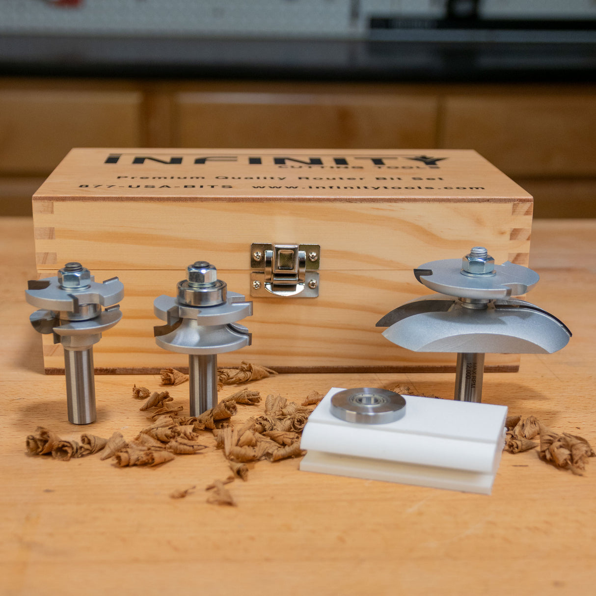 Set of woodworking router bits with wooden storage box on workbench