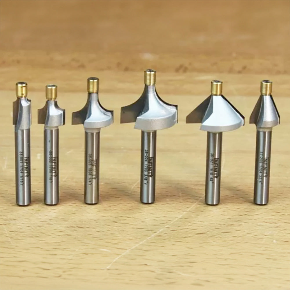 Set of six metal router bits for woodworking on a wooden surface