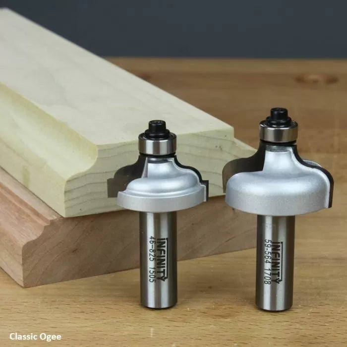 Two classic ogee router bits for woodworking, shown with routed wood edge profile on table.