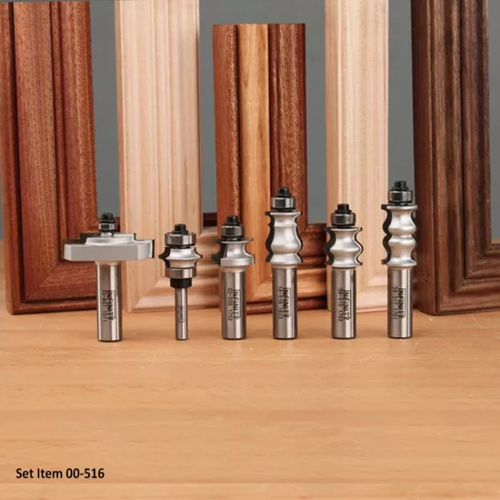 Set of woodworking router bits for decorative edge profiles, displayed with wood frames.