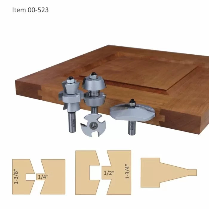 Cabinet door router bit set with carbide-tipped cutters and sample joint profiles on wood panel.
