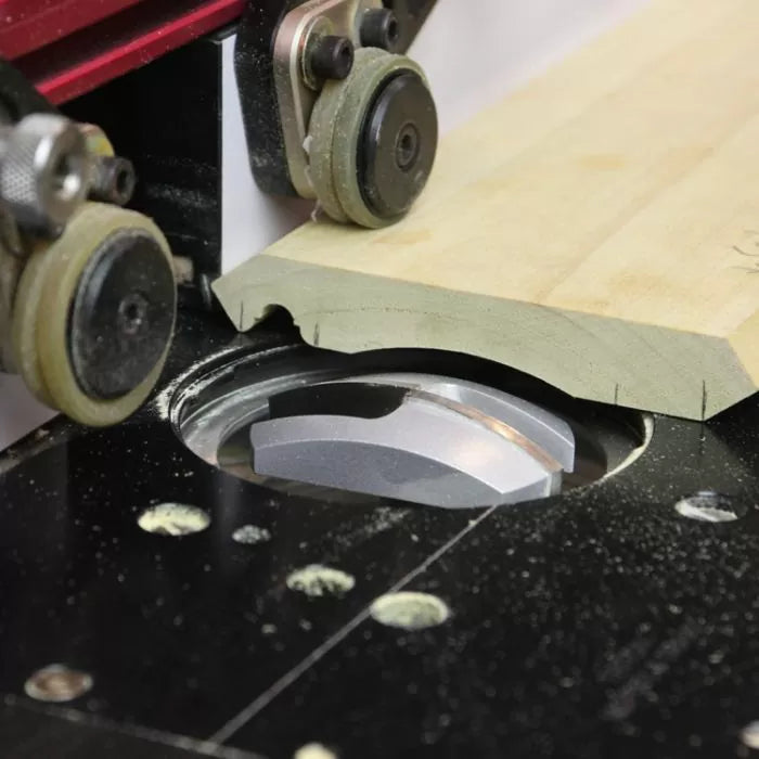 Woodworking router table cutting a decorative edge on a wooden board with a router bit