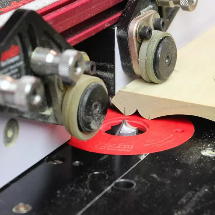 Router table with fence cutting decorative edge on wood using precision router bit