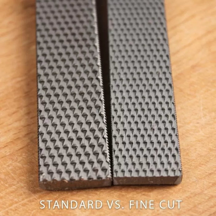 Close-up of standard cut and fine cut woodworking rasps on a wood surface