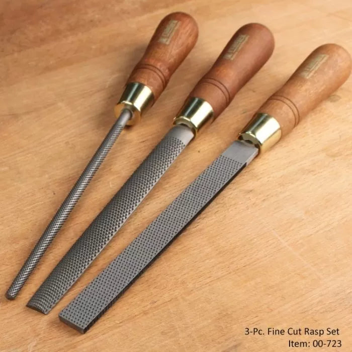 Three-piece fine cut rasp set with wooden handles on a woodworking bench