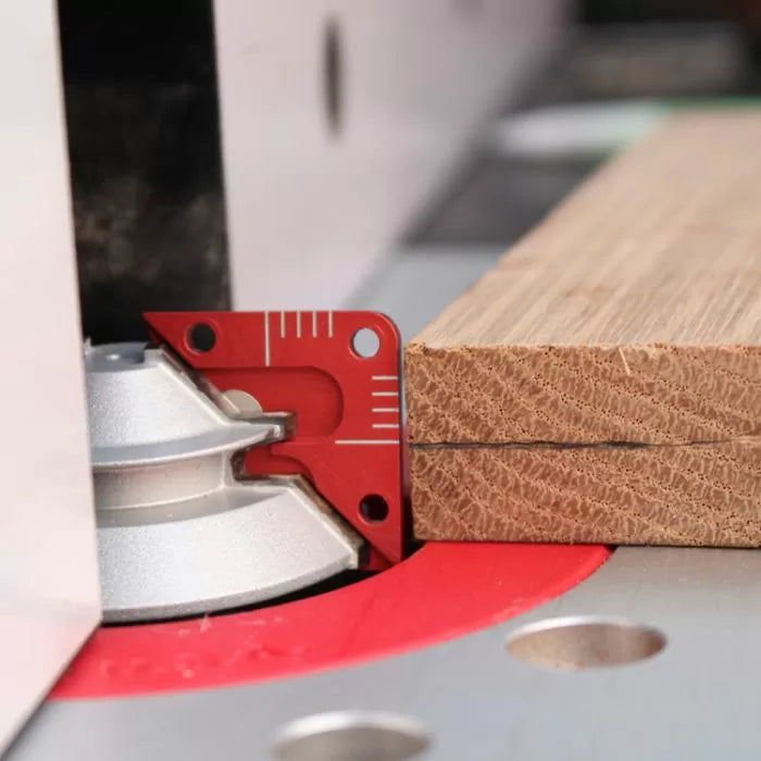 Router bit setup gauge measuring wood thickness on a router table for precise woodworking cuts.