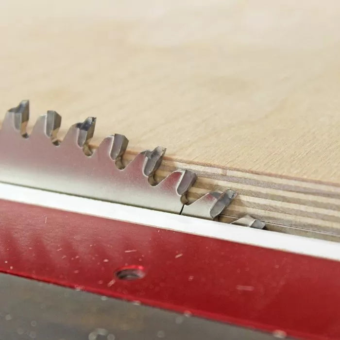 Close-up of a table saw blade cutting plywood for precise woodworking.