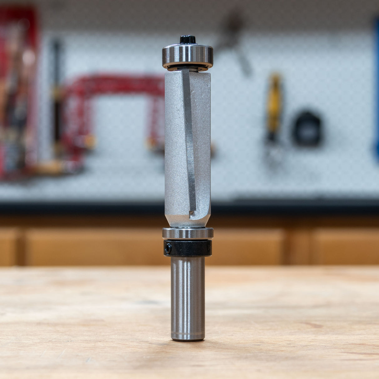 Infinity Tools double-bearing pattern router bit with downshear standing on a workbench