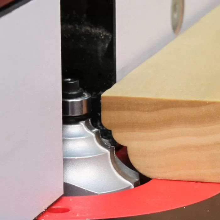Router bit shaping edge profile on wood using router table for woodworking