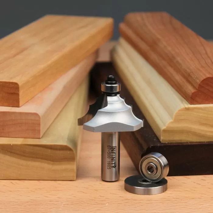 Woodworking router bit with bearings displayed among profiled wood trim pieces for routing projects