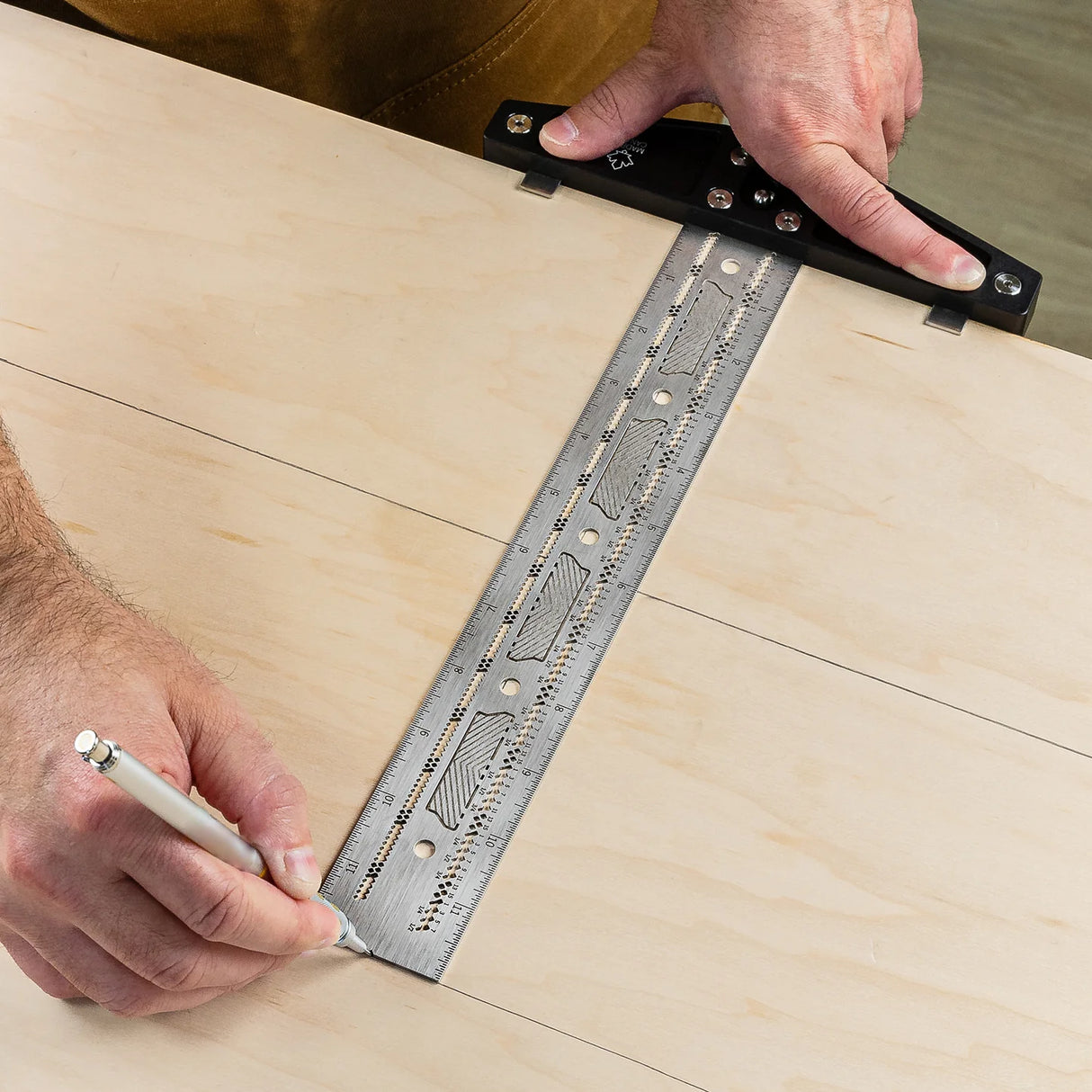Woodworker using precision T-square ruler to mark straight lines on plywood panel