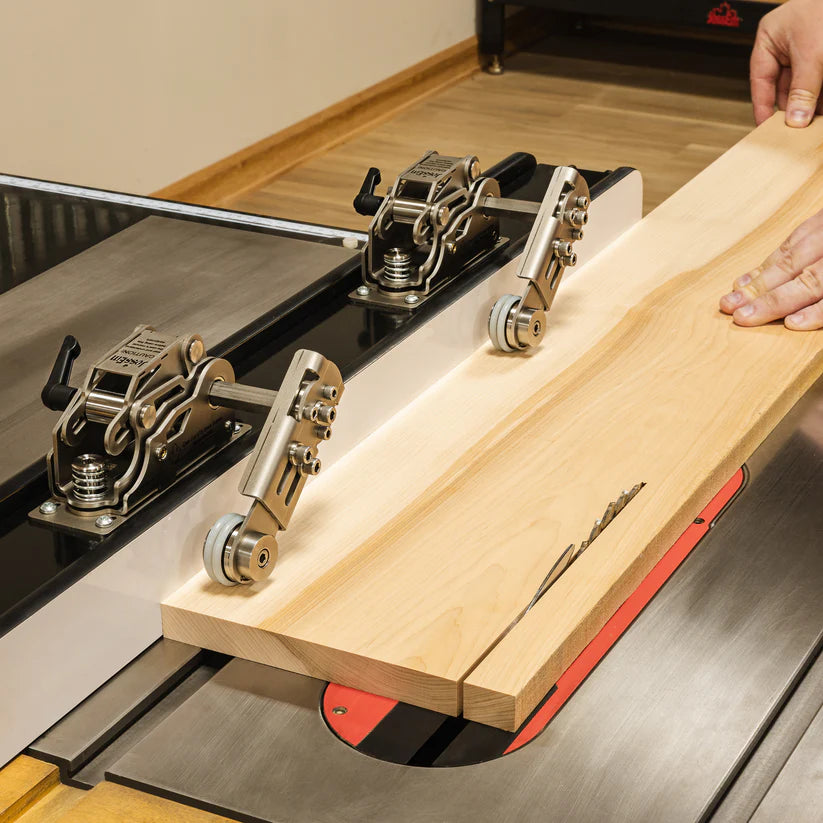 Table saw fence jig with hold-down clamps guiding a wooden board for precise cutting