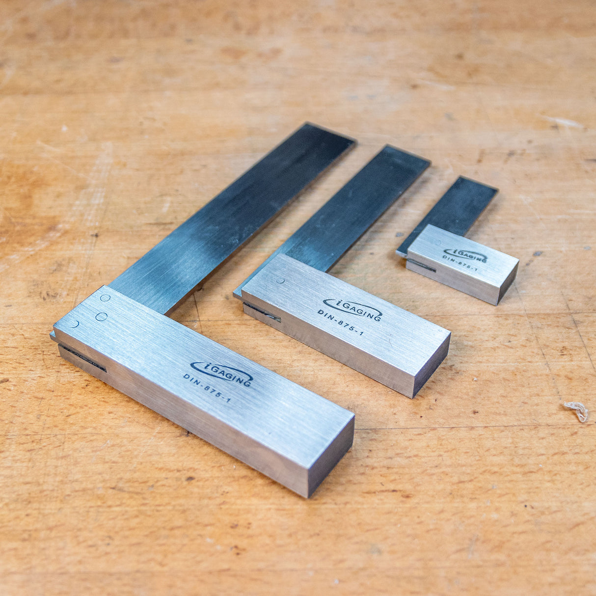 Set of three precision woodworking squares on a wooden workbench