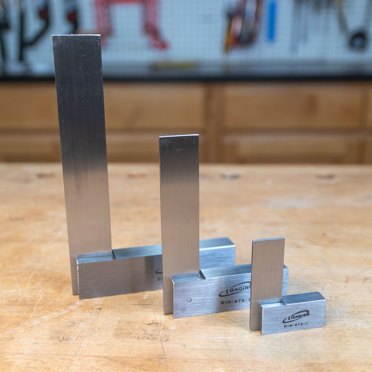 Set of four precision steel woodworking squares on a workshop bench