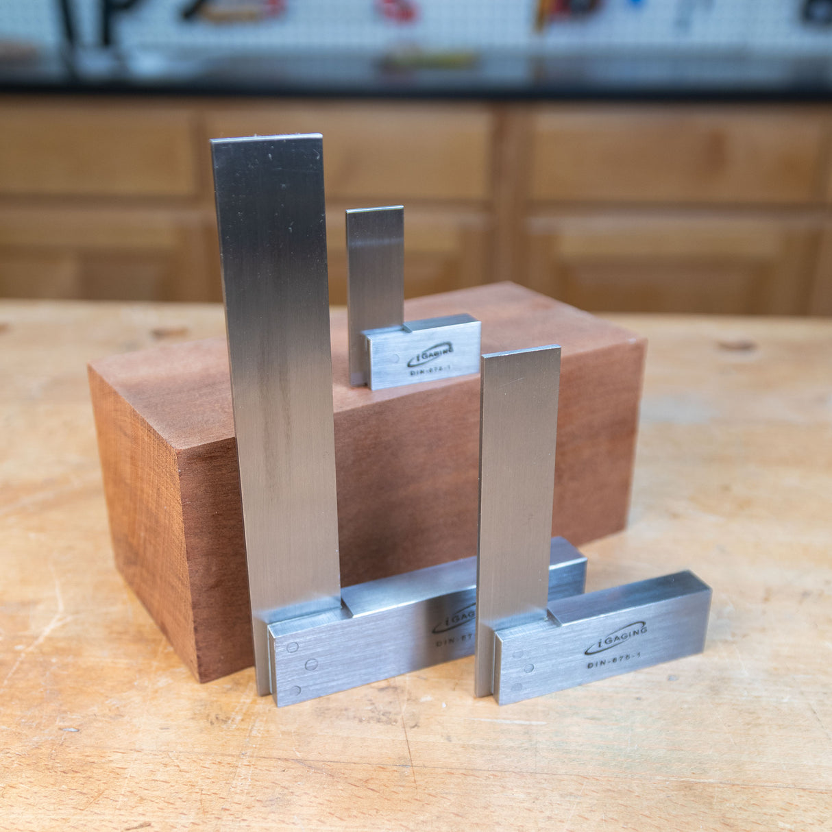 Set of precision woodworking squares on a wooden block in a workshop setting