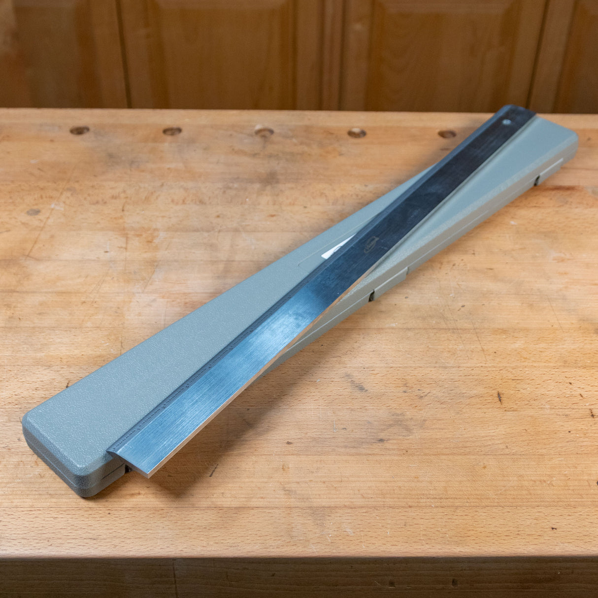 Precision straight edge woodworking tool on a wooden workbench