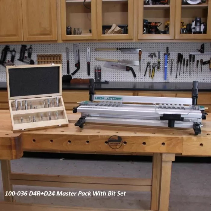 Dovetail jig and router bit set on workbench in woodworking shop with tools in background.