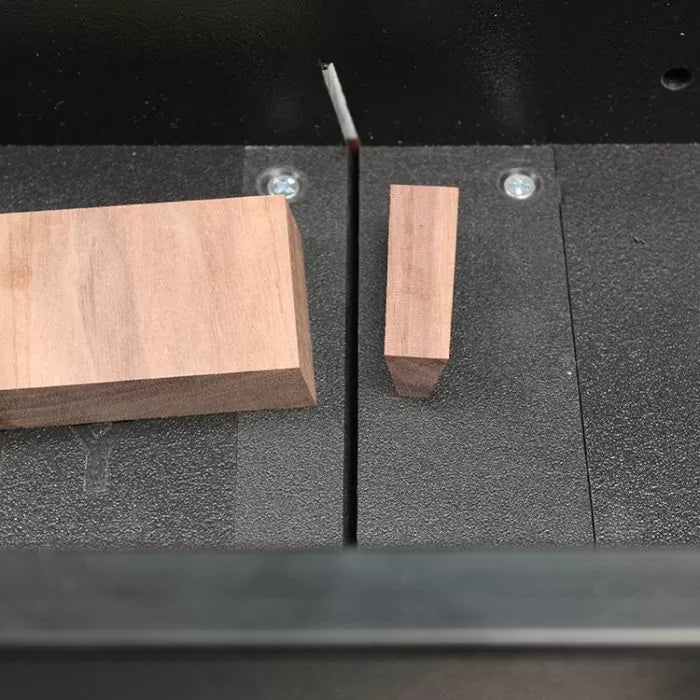 Closeup of two wood blocks on a table saw with a visible saw blade, woodworking tools setup