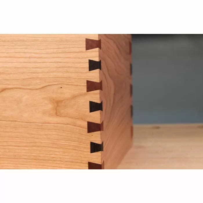 Closeup of wooden box corner with precise dovetail joints on a smooth workbench