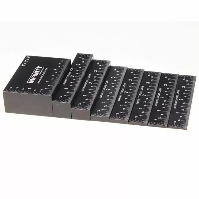 Set of black precision woodworking setup blocks with inch markings, arranged in a row