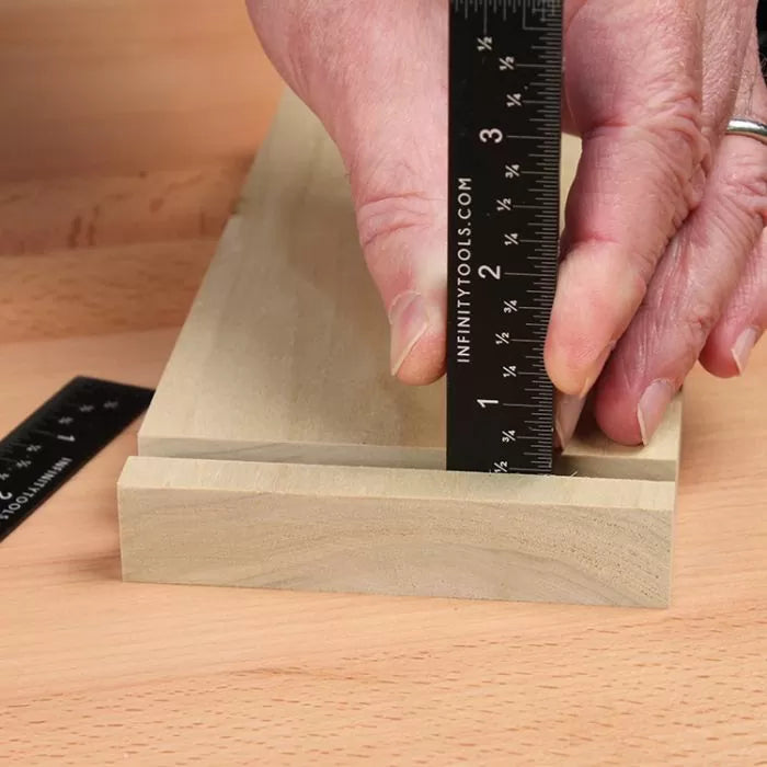 Measuring wood joinery depth with a precision black steel woodworking ruler