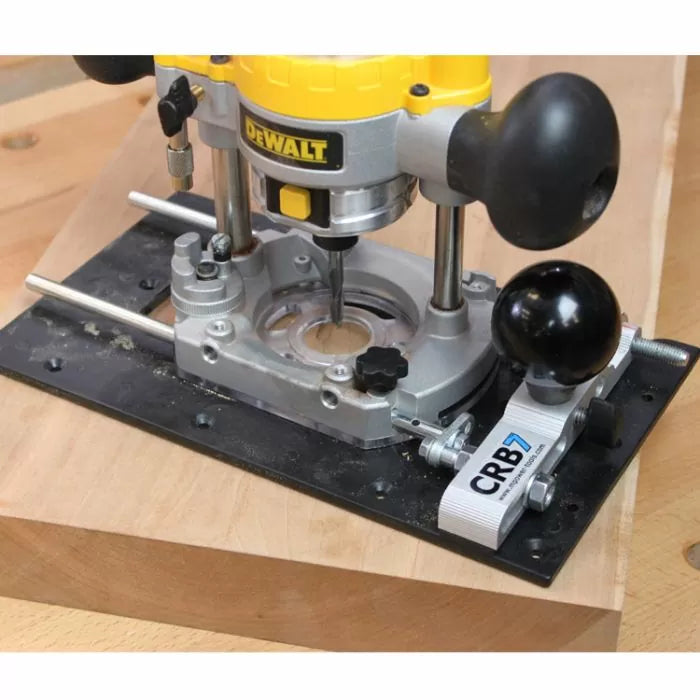 Plunge router with guide base making precise cut in wood on a workbench
