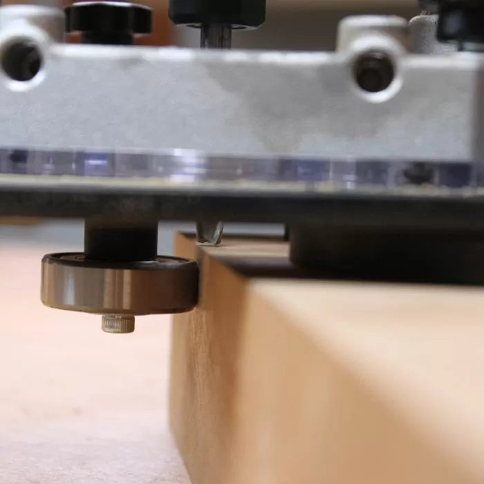 Close-up of a woodworking router with bearing guided bit cutting edge on wood