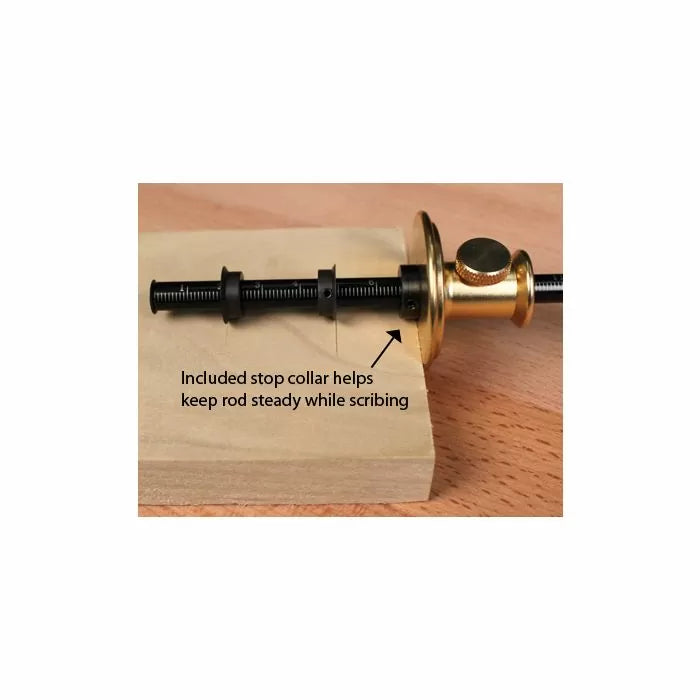 Brass marking gauge with stop collar on wooden board for precise woodworking scribing