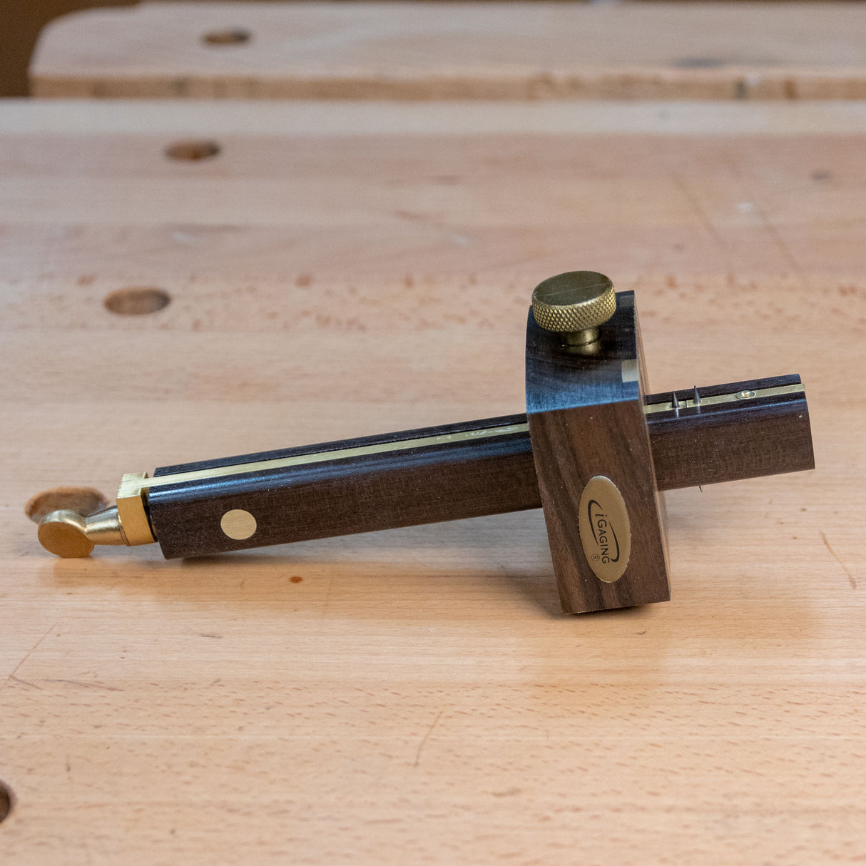 Ebony marking gauge with brass accents on a wooden workbench for precision woodworking