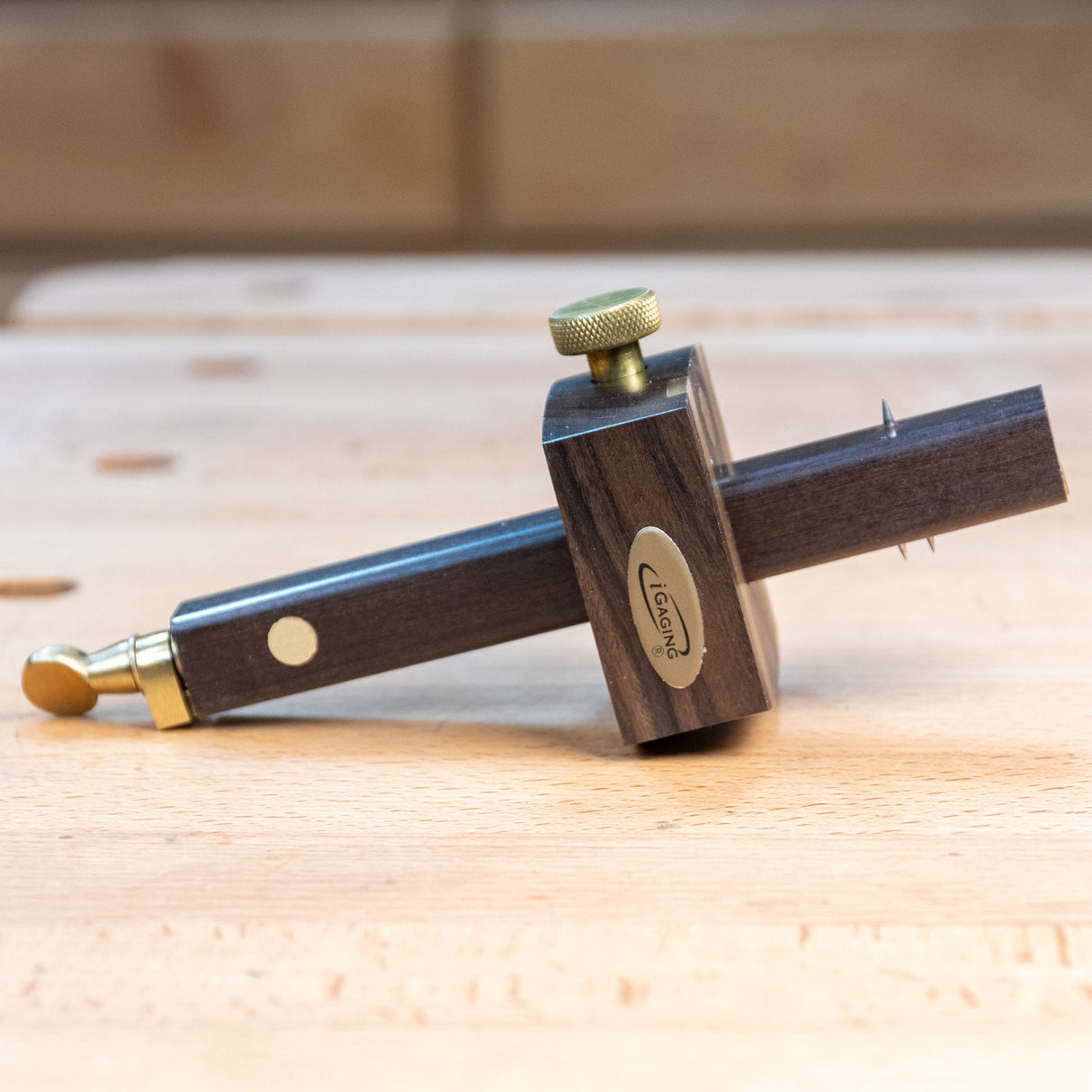Ebony marking gauge with brass accents on a wooden workbench for woodworking layout