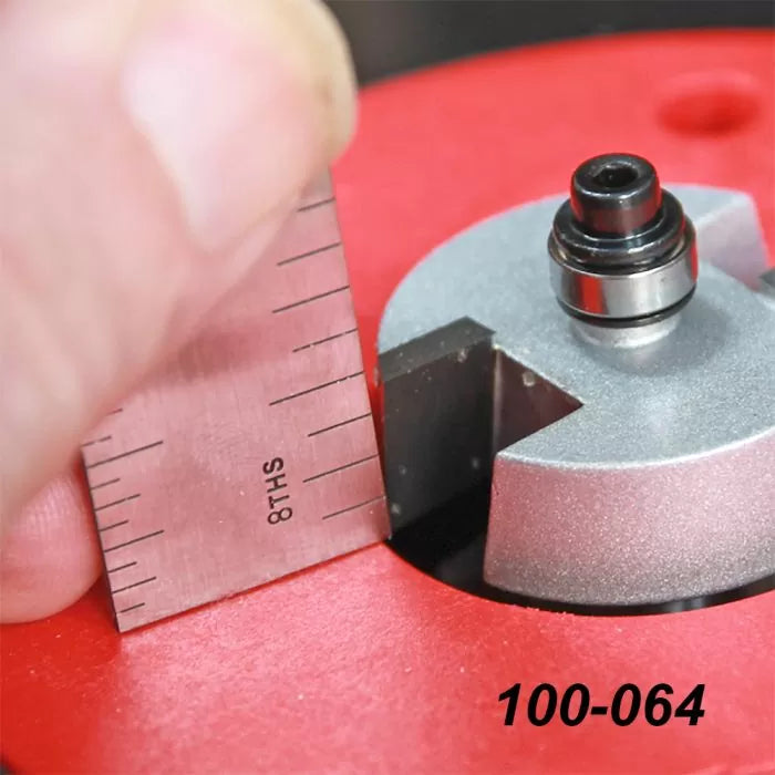 Close-up of measuring a router bit height with ruler on red router table