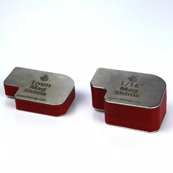 Stacked 1mm and 1/16 inch magnetic shims with red edges on a white background