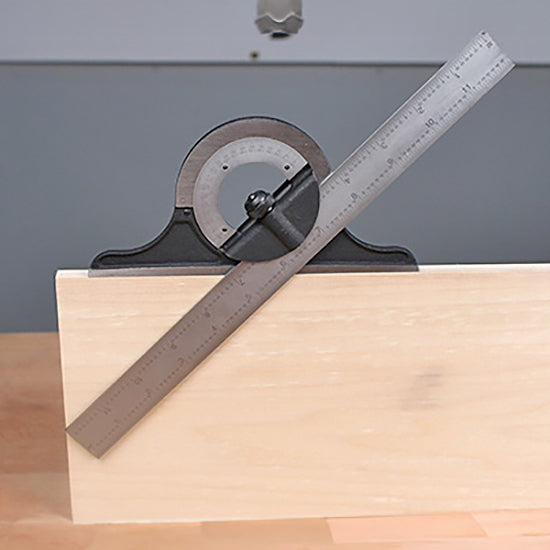 Protractor combination square measuring angle on a wooden board in a workshop setting