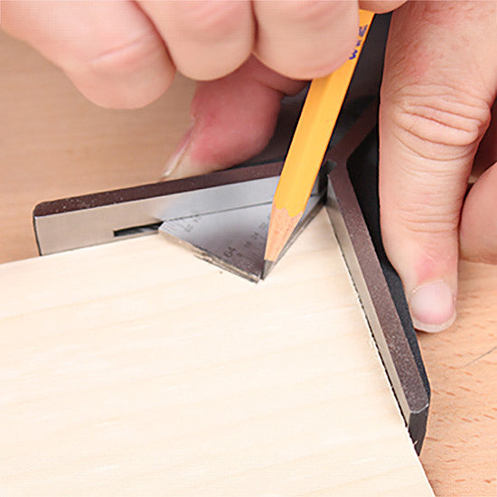 Hand using a try square and pencil to mark precise right angle on wood for woodworking.