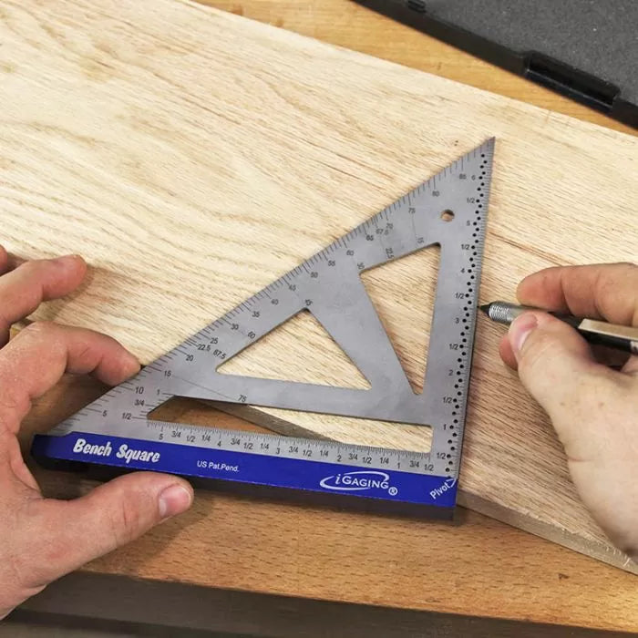 Woodworker using a metal bench square to mark measurements on a wood board