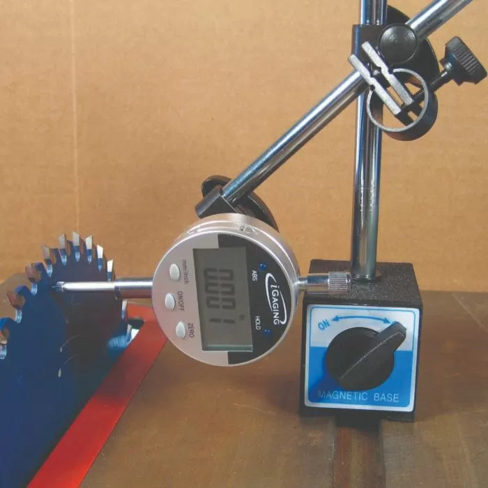 Digital dial indicator with magnetic base measuring saw blade runout on a metal table