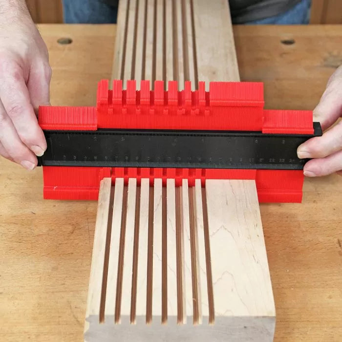 Red contour gauge measuring wood grooves for precise woodworking and joinery fitting