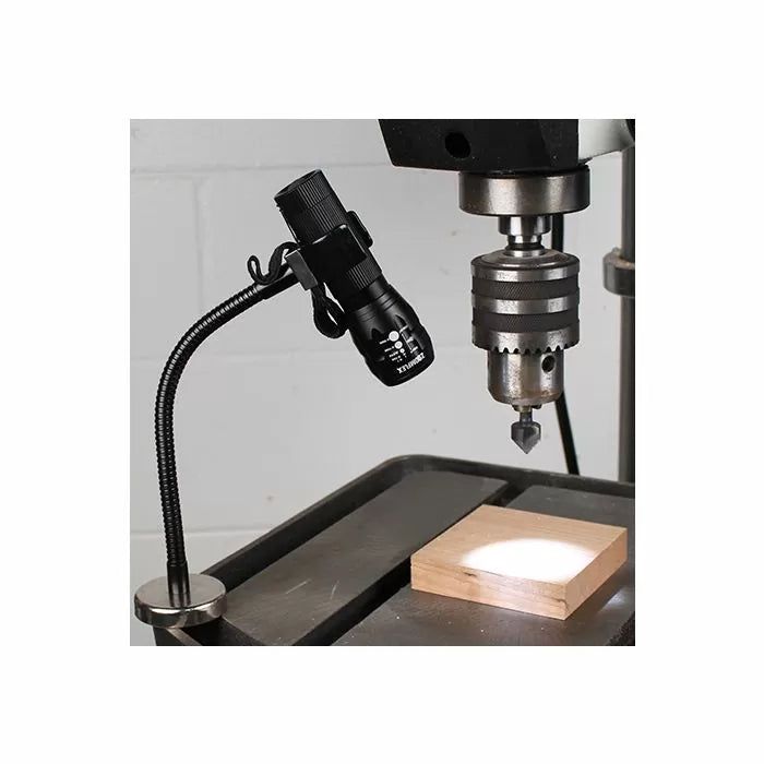 Magnetic LED work light attached to a drill press, illuminating a wood block for woodworking precision.
