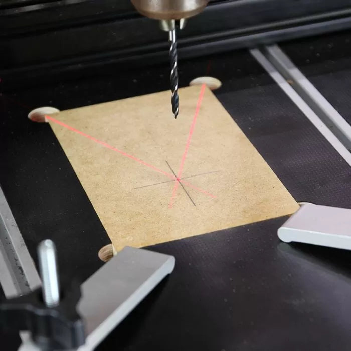 Drill press with laser guide aligns for precise wood drilling on marked board
