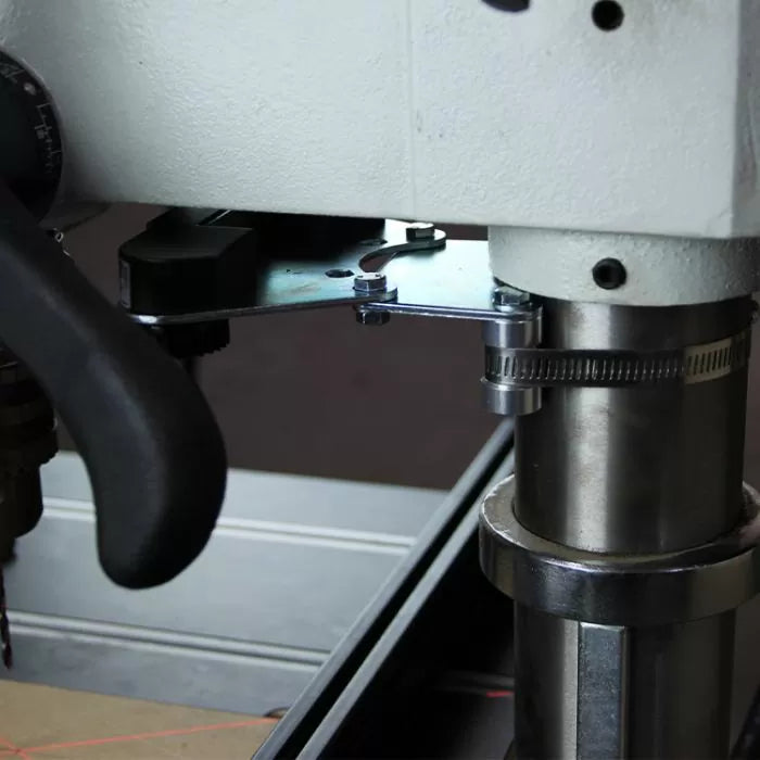 Close-up of a drill press depth stop collar installed on a woodworking drill press