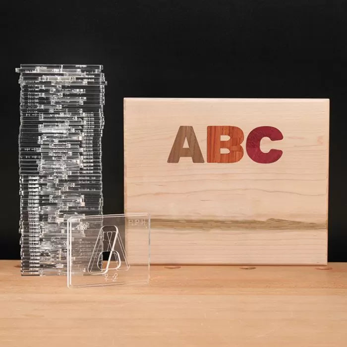Acrylic letter templates and wooden box with ABC inlaid, woodworking tool set on table
