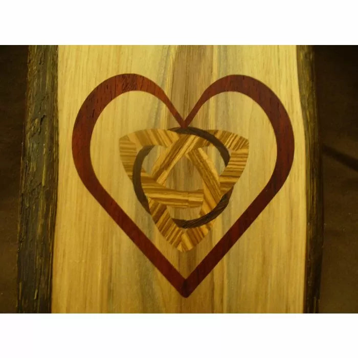 Wood inlay heart with knot pattern on a natural wood surface, woodworking project detail