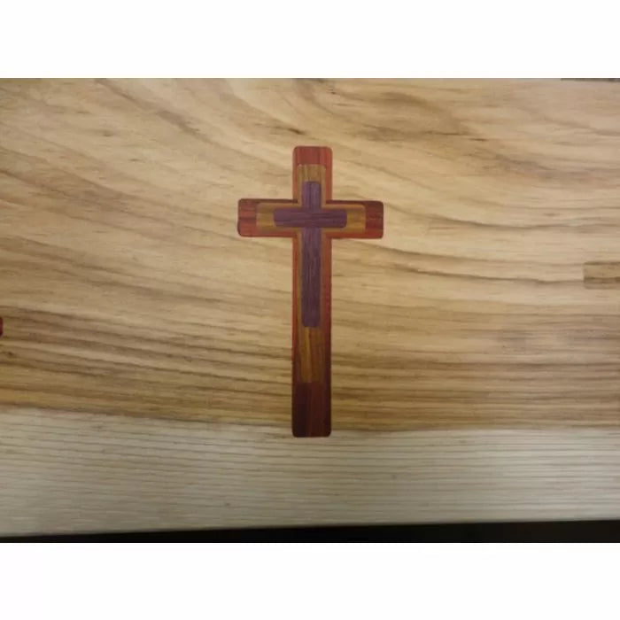Wood inlay cross design on light wood surface, woodworking precision example