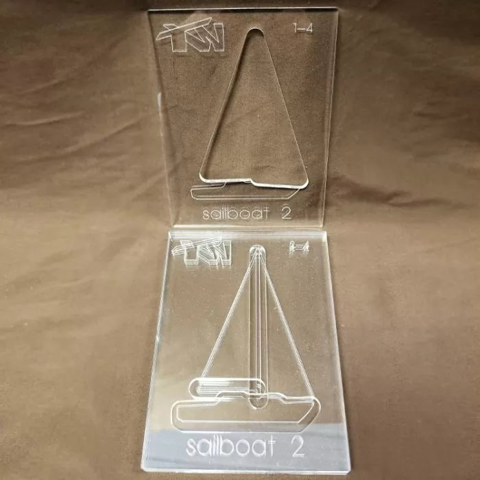 Clear acrylic sailboat template set for woodworking projects on a brown surface