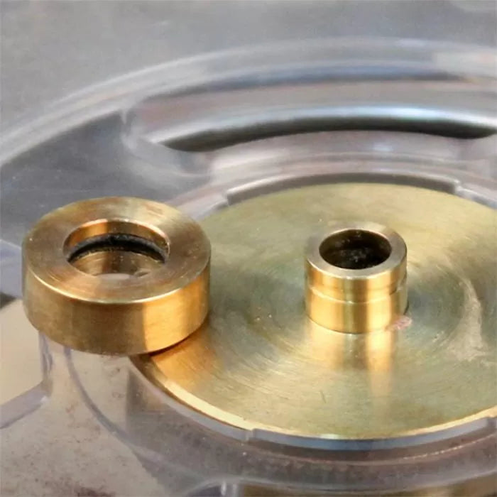 Brass router table insert rings on a clear router plate, woodworking tool accessory