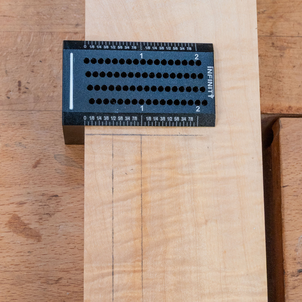 Precision woodworking saddle square in use marking lines on a wood board.