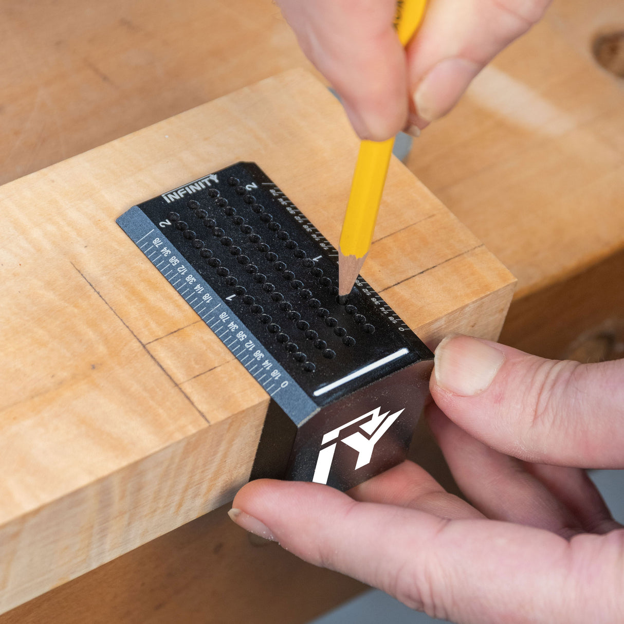 Woodworker using a saddle square marking guide on a wooden board for precise layout